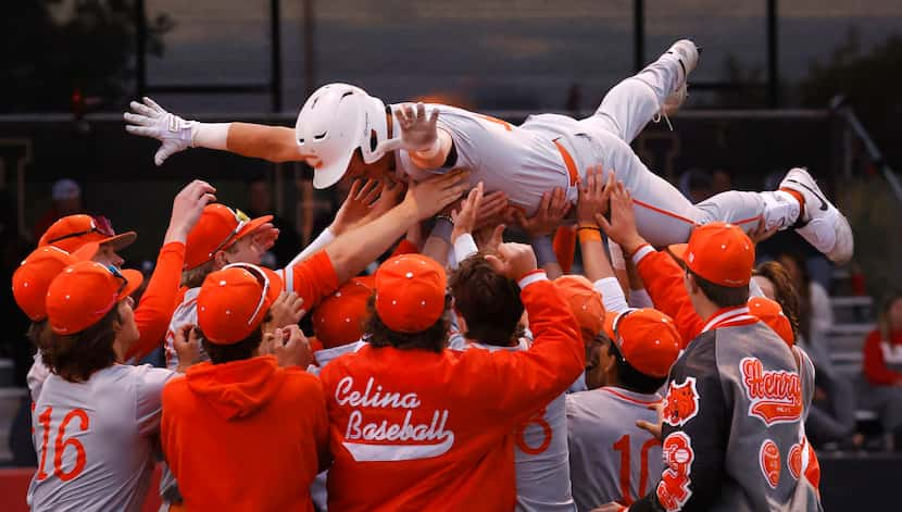 Celina's Kingston Hangartner (top) is congratulated by teammates after hitting a home run...