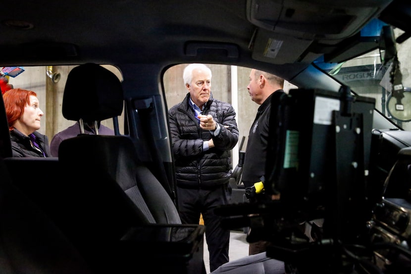 Sen. John Cornyn, R-Texas, center, points towards a Right care SUV while talking to Dallas...