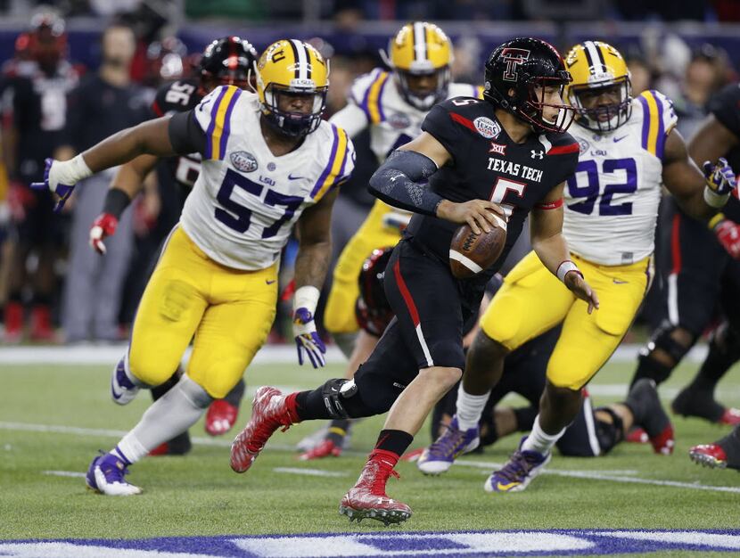 Texas Tech quarterback Patrick Mahomes (5) runs out of the pocket as he receives pressure...