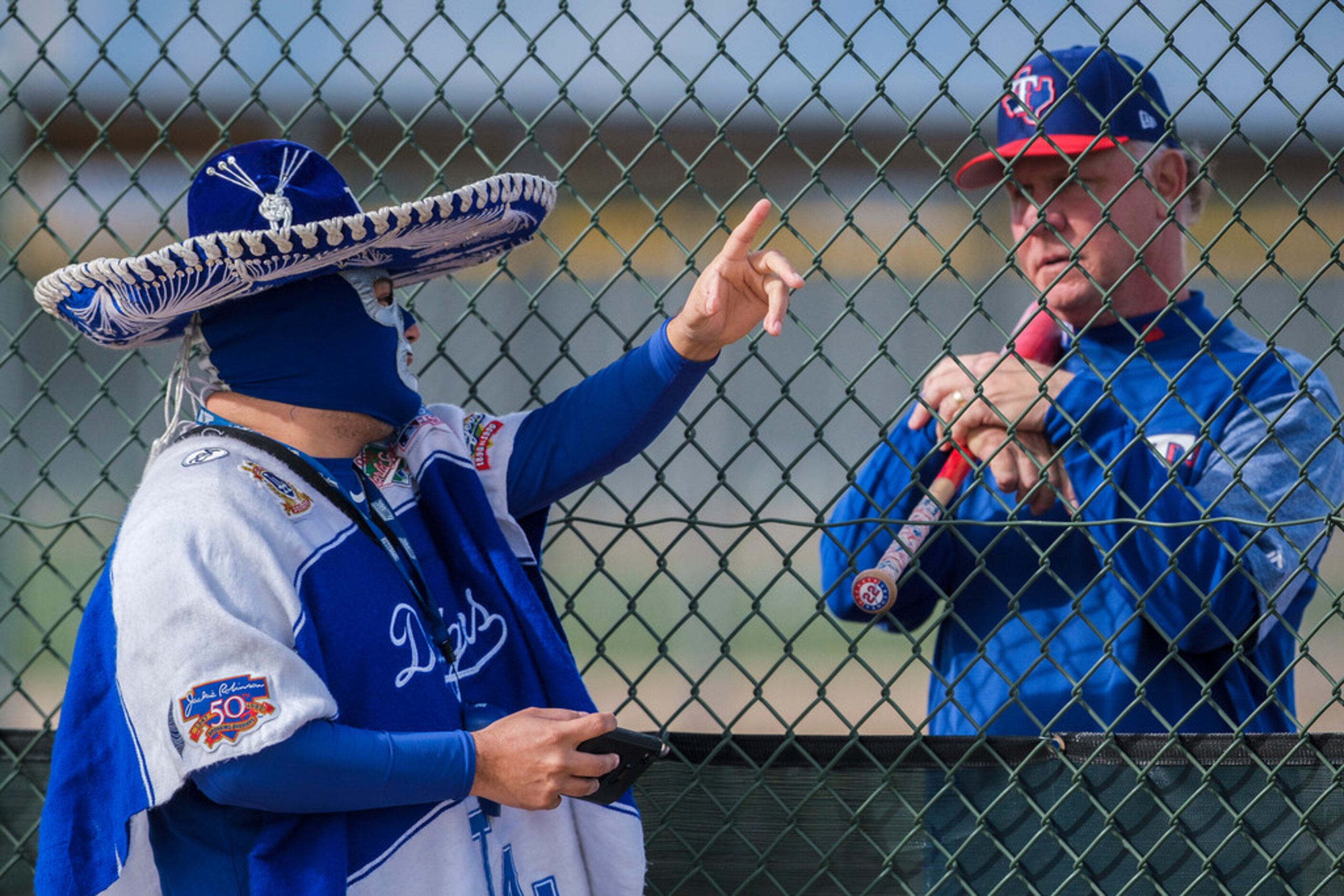 Los Angeles Dodgers fan Carlos Morales chats with Texas Rangers special assistant, baseball...