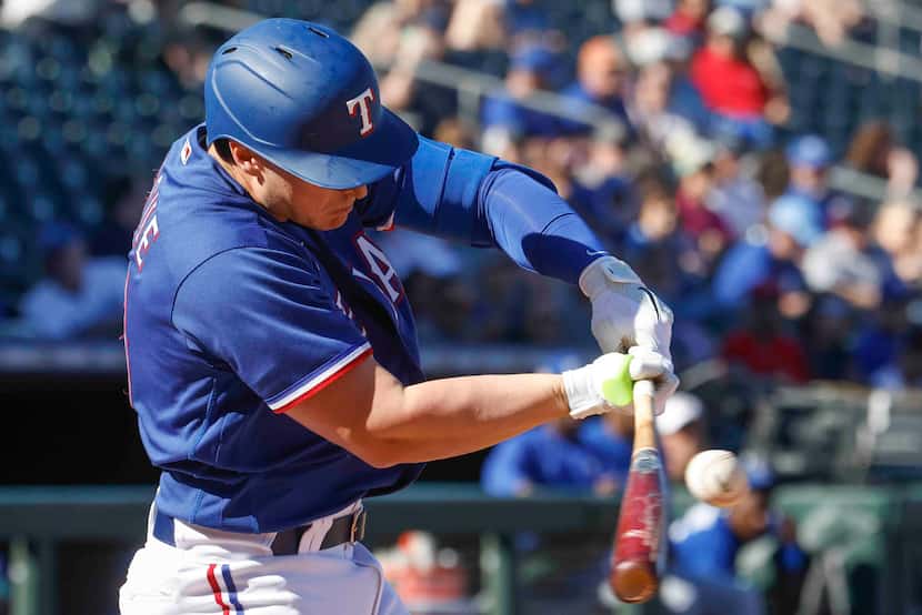Texas Rangers infielder Justin Foscue hits during the sixth inning of a spring training game...