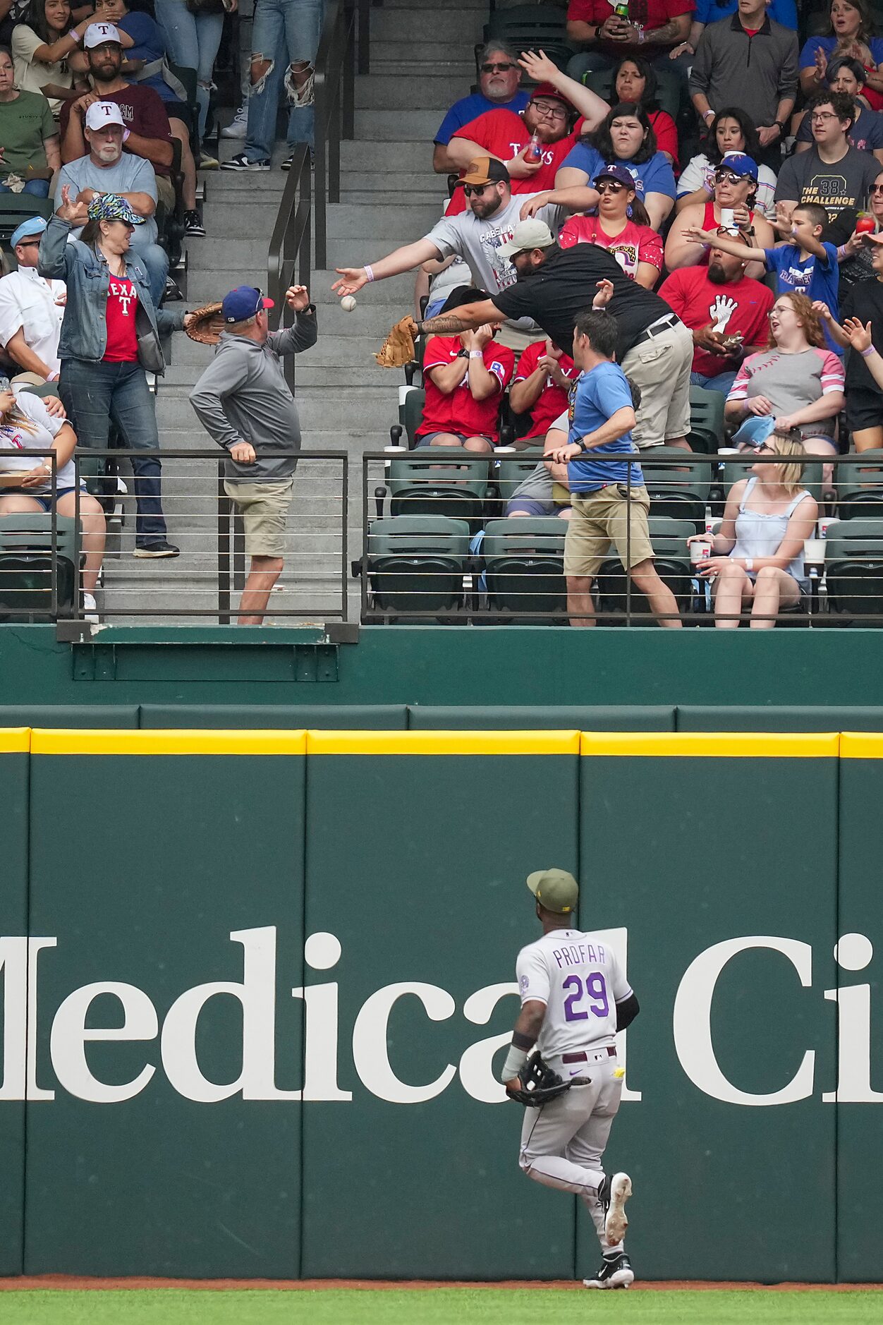 Fans try to catch a solo home run off the bat of Texas Rangers third baseman Josh Jung...