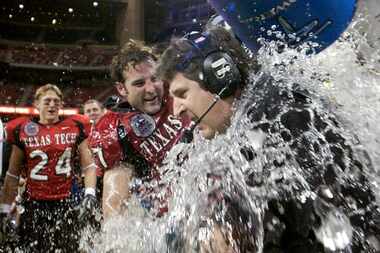 FILE - Texas Tech coach Mike Leach, center, is dunked with water by Wes Welker (27), left,...