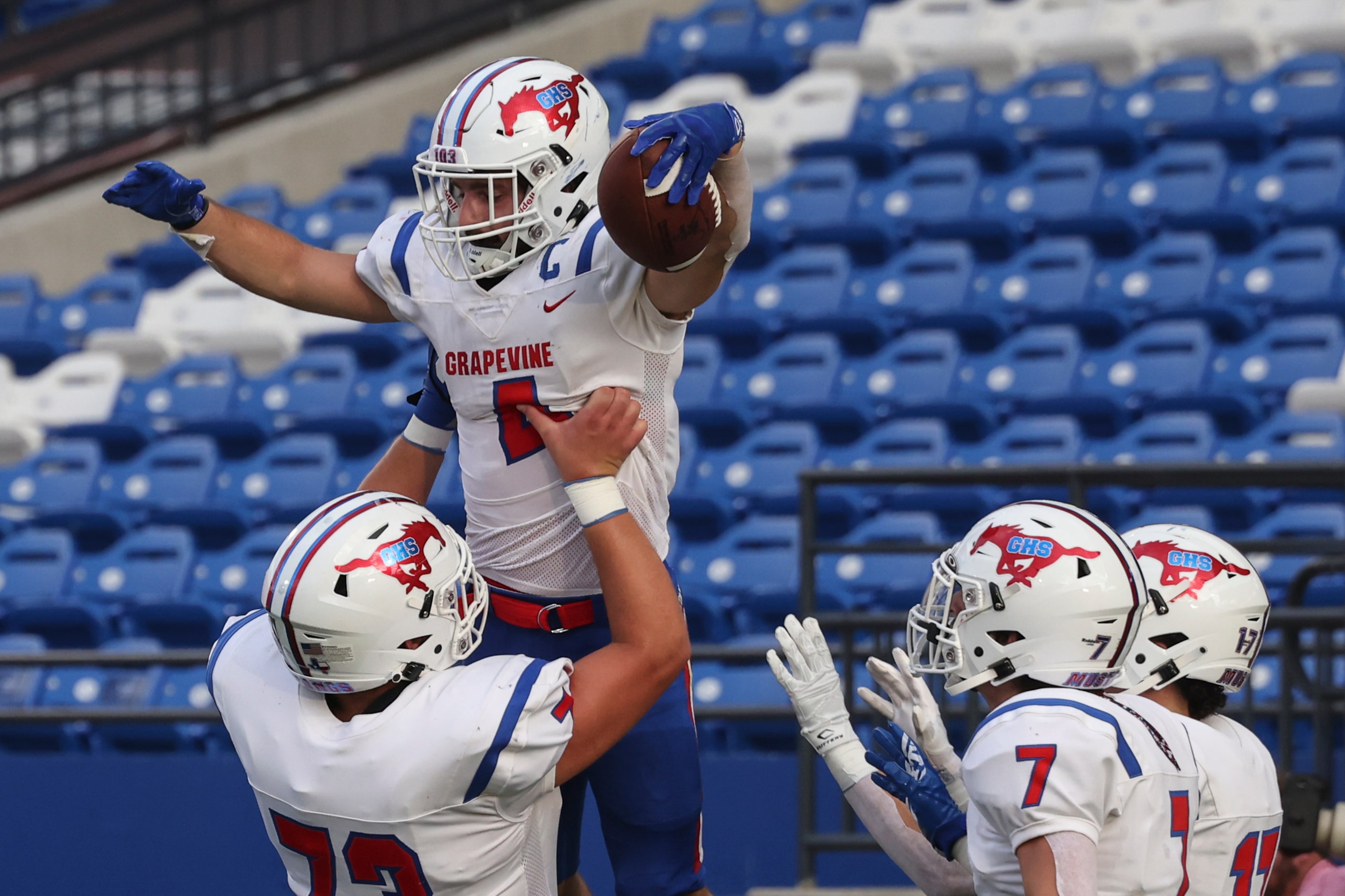 Grapevine High School’s Parker Polk (4) is hoisted into the air by Sie Owen (73) after...