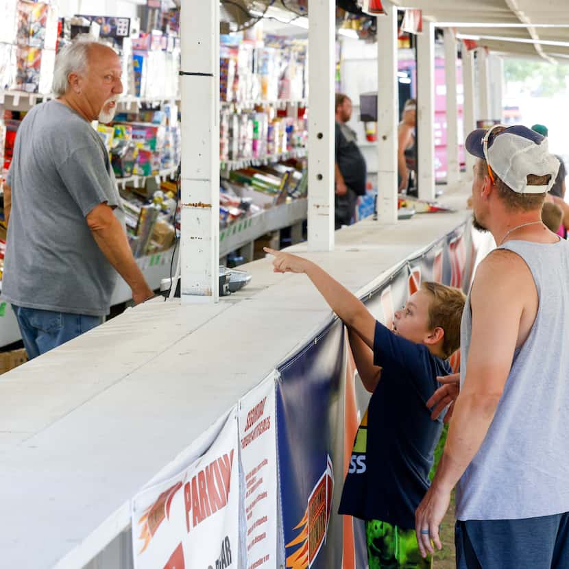 David Byrne helps Levi Wheeler and his son Declan Wheeler, 7, shop for fireworks at Pyro...