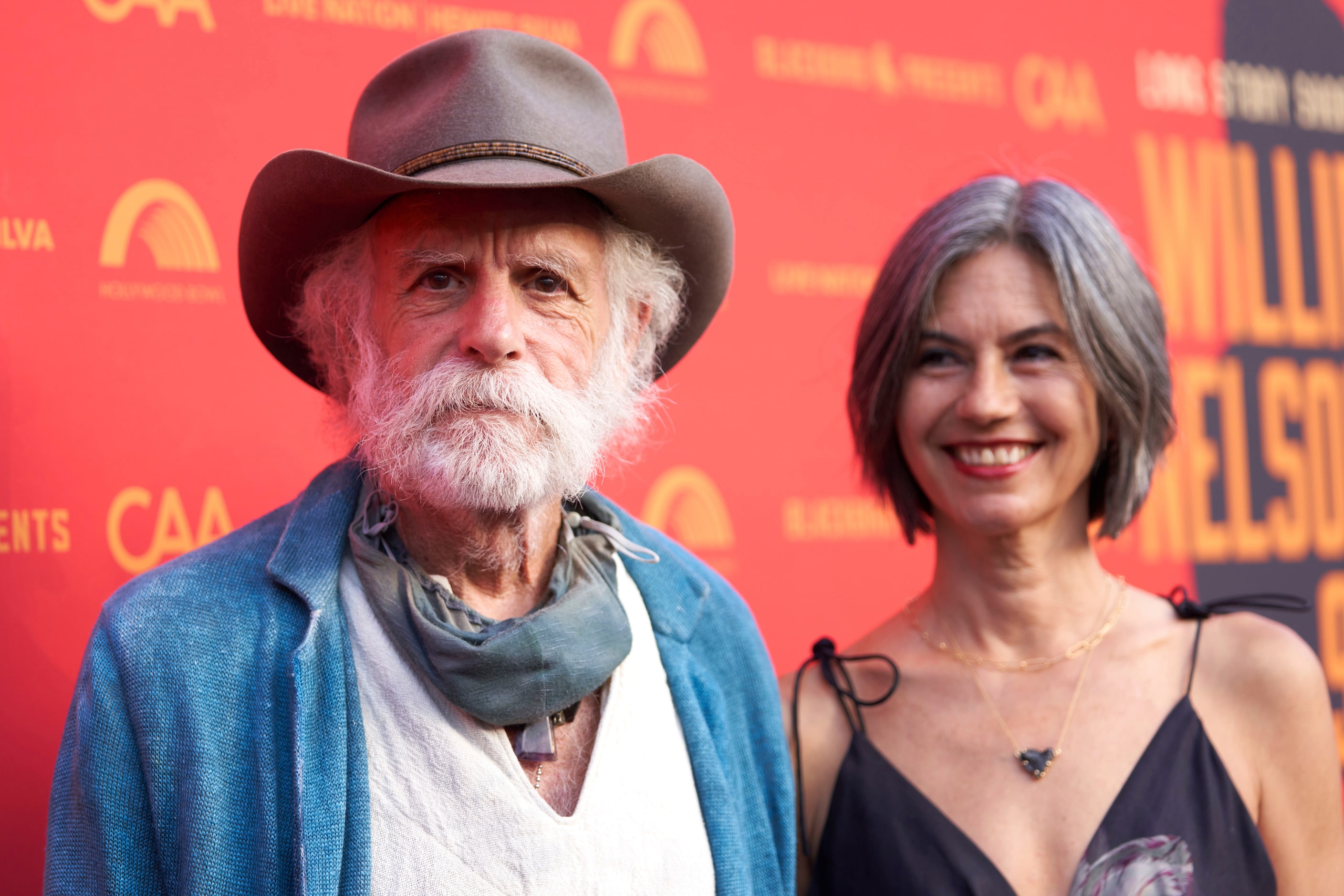 Bob Weir, left, and Natascha Munter arrive at Willie Nelson 90, celebrating the singer's...