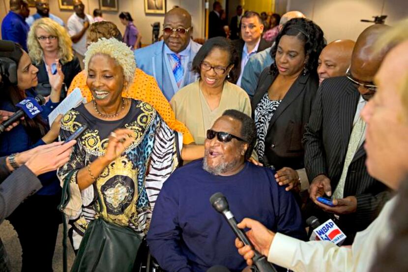 
Michael Phillips, 57, is surrounded by friends, family and fellow exonerees on Friday,...