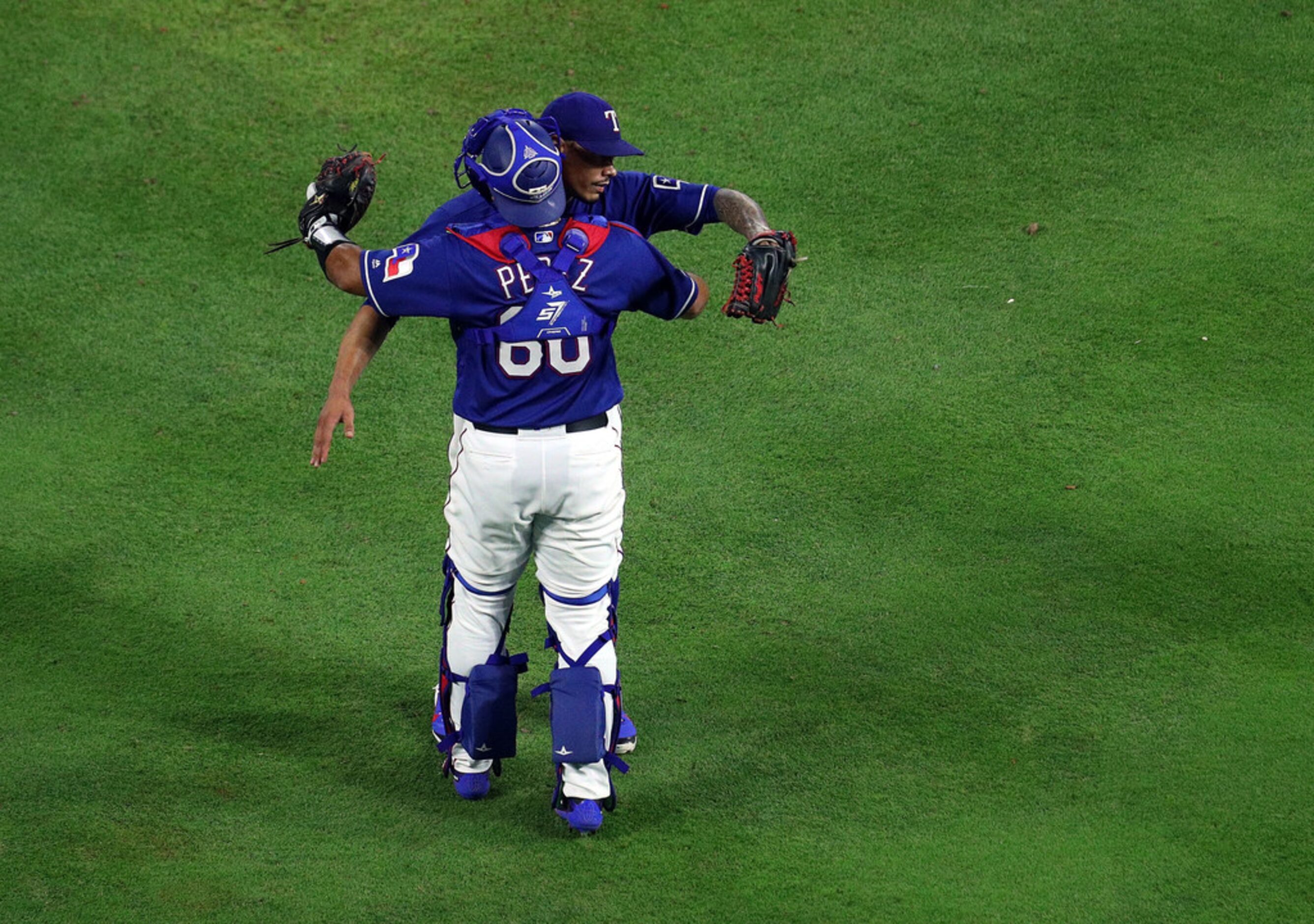 ARLINGTON, TX - MAY 23:  Keone Kela #50 of the Texas Rangers hugs Carlos Perez #60 of the...