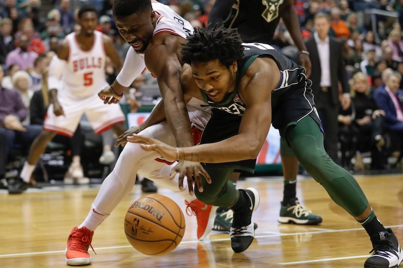 Chicago Bulls' David Nwaba and Milwaukee Bucks' Sterling Brown battle for a loose ball...