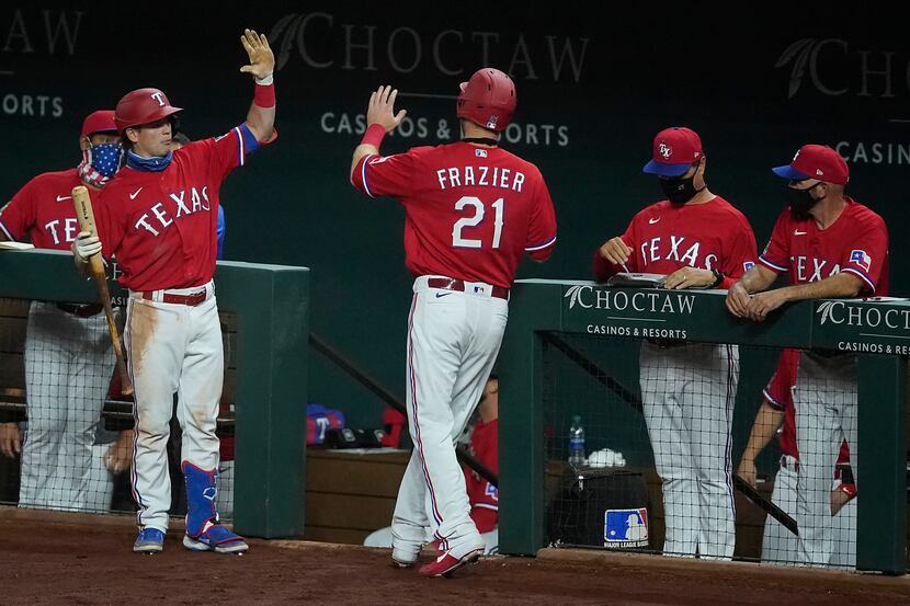 Texas Rangers third baseman Todd Frazier gets a socially distanced high five from outfielder...