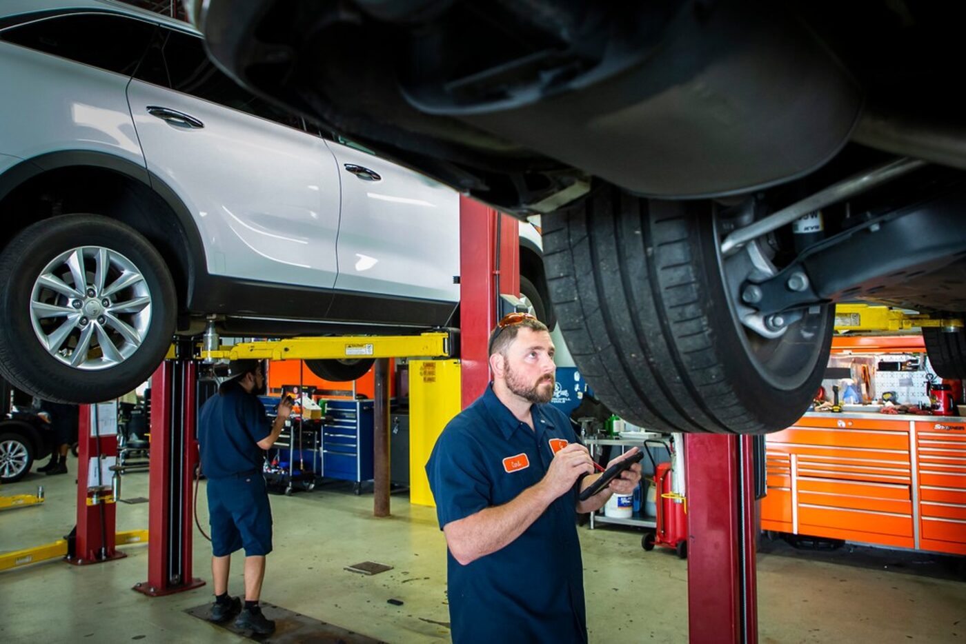 Carl Brown (front) and Efrain Banuelos inspect vehicles at driversselect in Grand Prairie. 