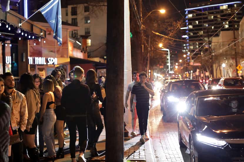 People crowd the sidewalks and streets as they wait to enter a variety of Uptown nightclubs...
