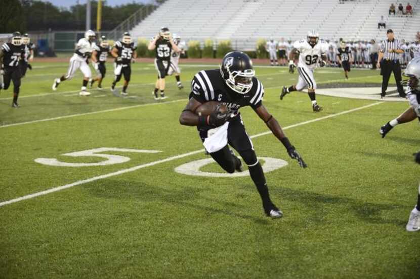 
Bishop Lynch’s Tremel Glasper carries the ball during a game against Fenwick High School...