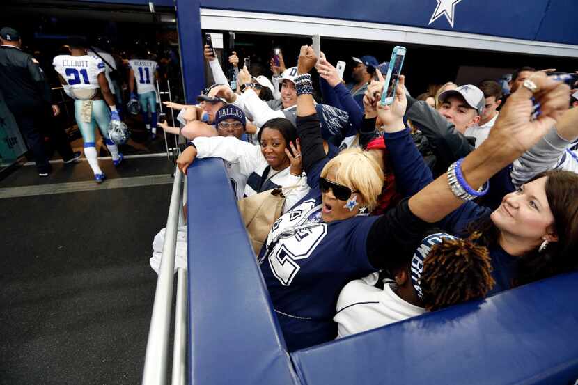 Carolyn Price (front, center, with arms up) before a game between the Dallas Cowboys and...