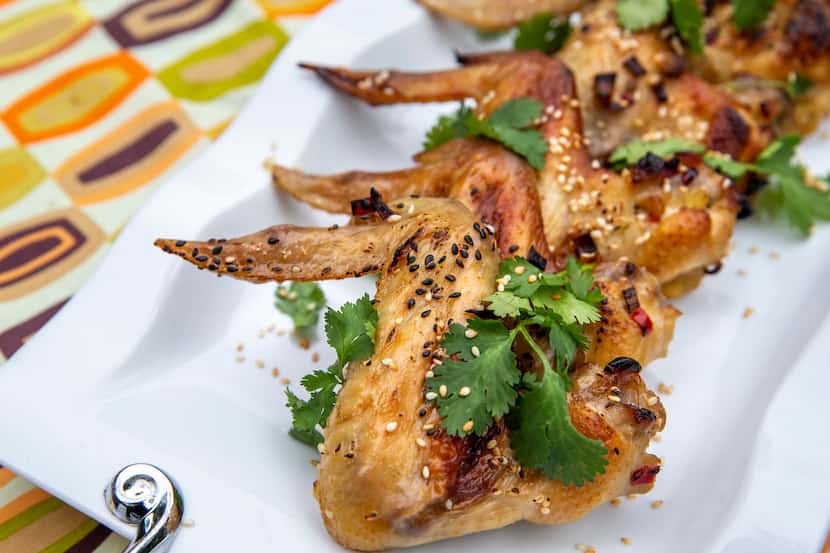 Glazed Sesame Chicken Wings dressed with cilantro and sesame seeds 