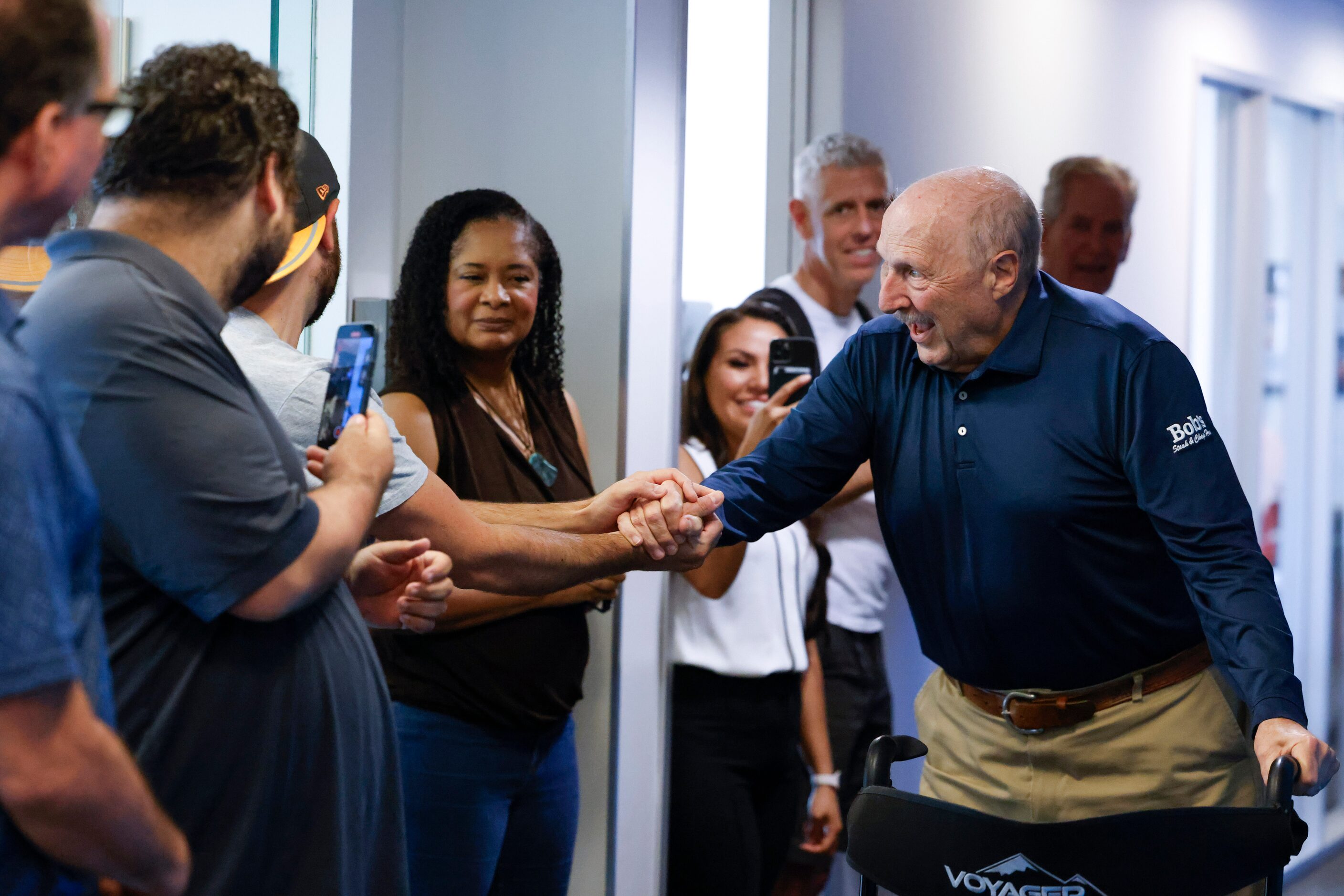 Local sports radio legend Norm Hitzges reacts as he walks through a honor walk after his...