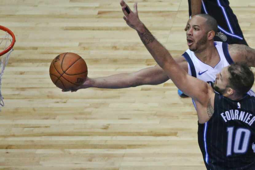 Dallas Mavericks guard Devin Harris (34) drives to the basket despit the defensive efforts...