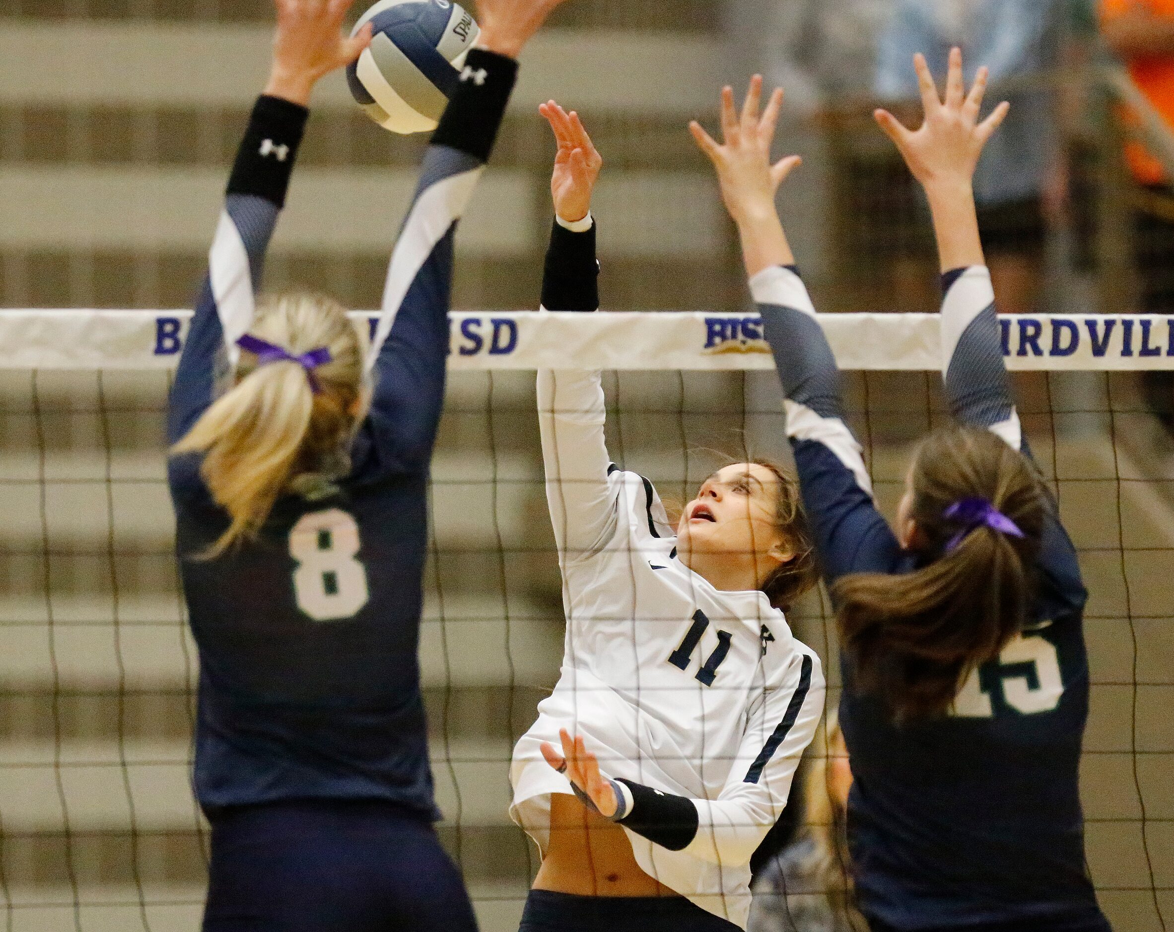 Keller High School outside hitter Melanie McGann (11) attempts a hit as V.R. Eaton High...