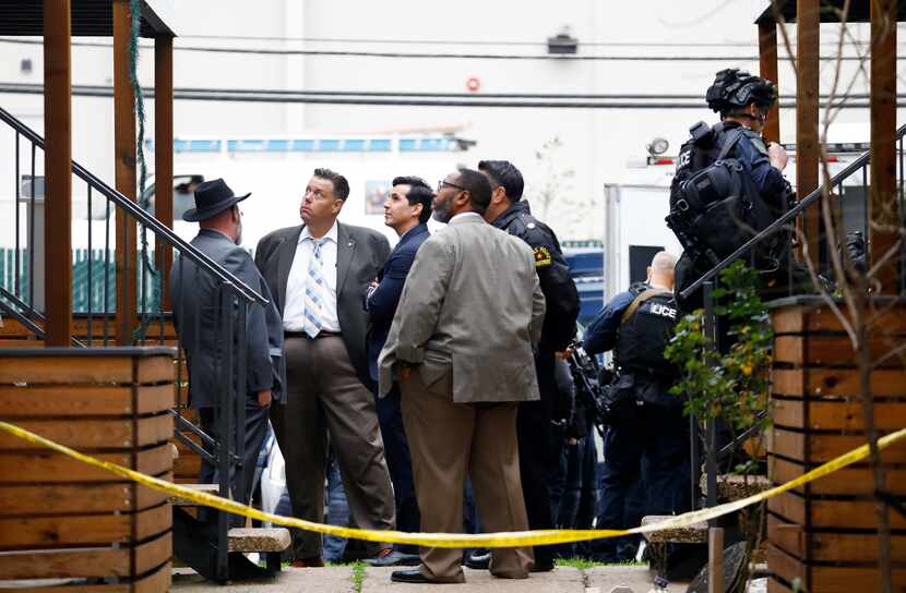 Dallas police investigators look up at an apartment at 6003 Abrams Road where two children...