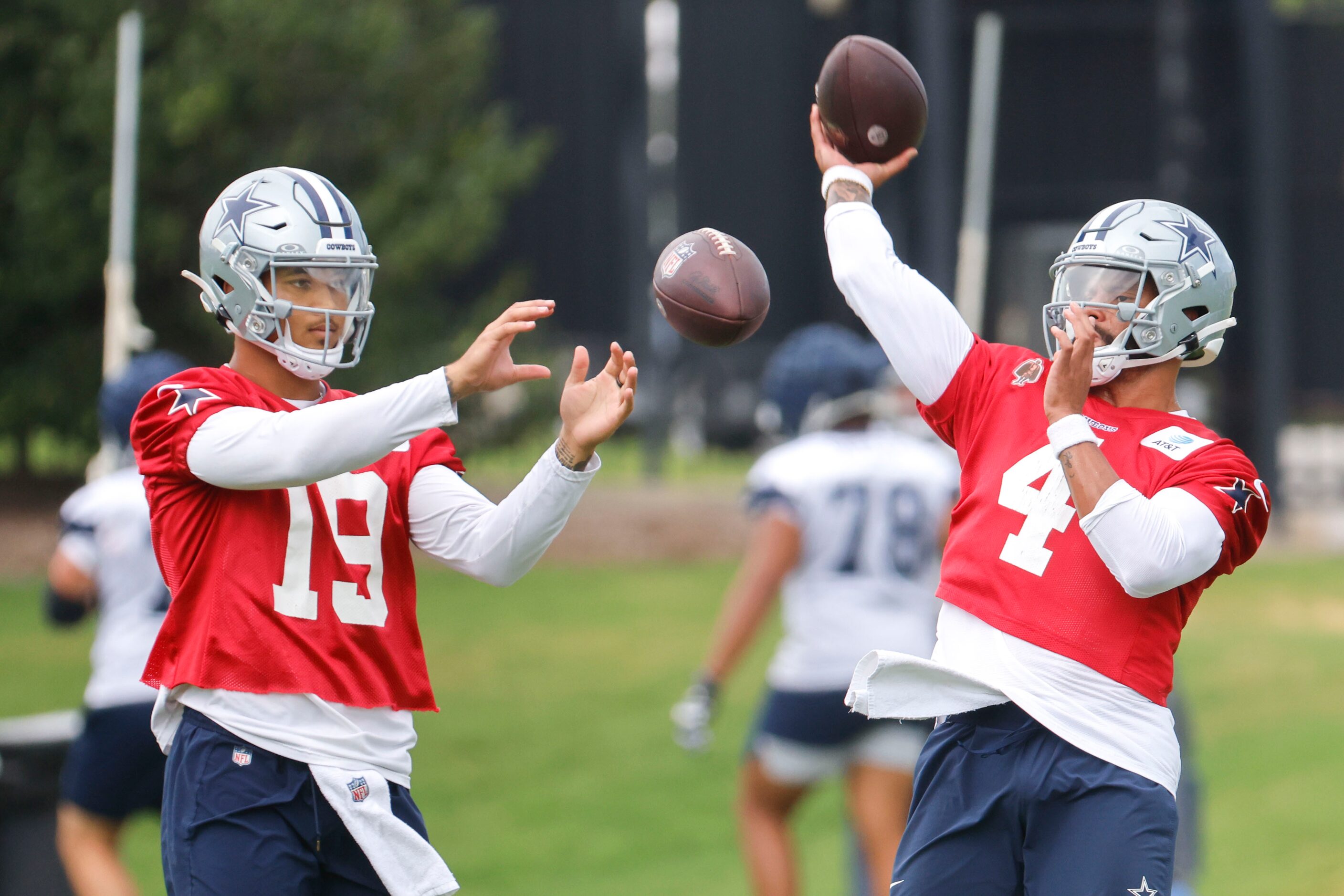 Dallas Cowboys quarterback Trey Lance (19) and quarterback Dak Prescott (4) take part during...