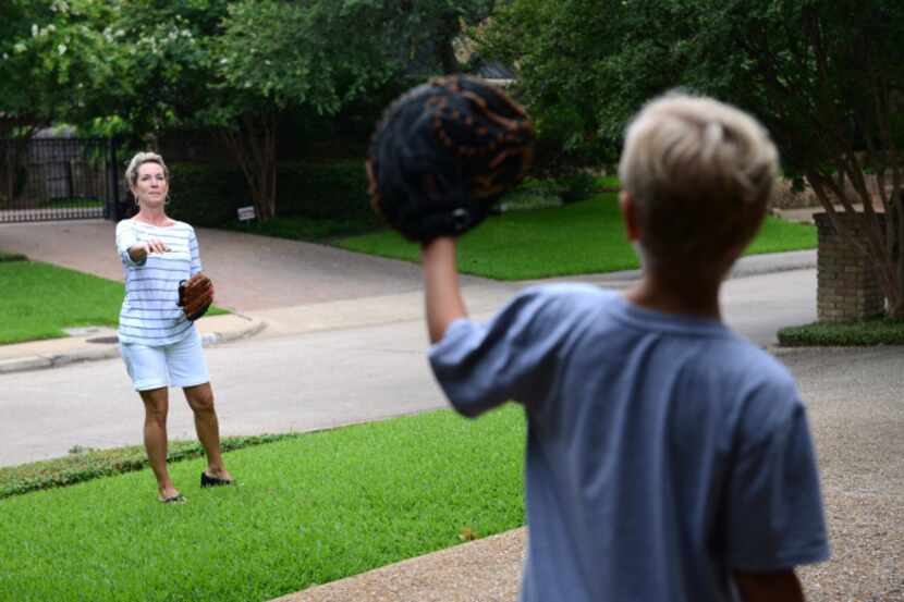 Janelle Rawlston tosses a baseball to her son Matt, 10, at their home in Bent Tree North, ...