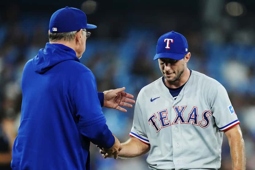 Texas Rangers starting pitcher Max Scherzer, right, is taken out of the baseball game...