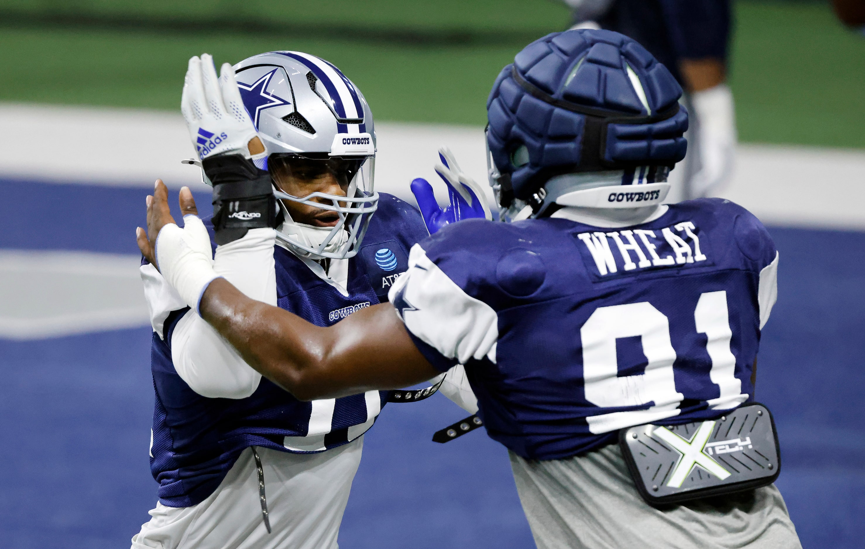 Dallas Cowboys linebacker Micah Parsons (facing) and defensive end Tyrus Wheat (91)  work on...