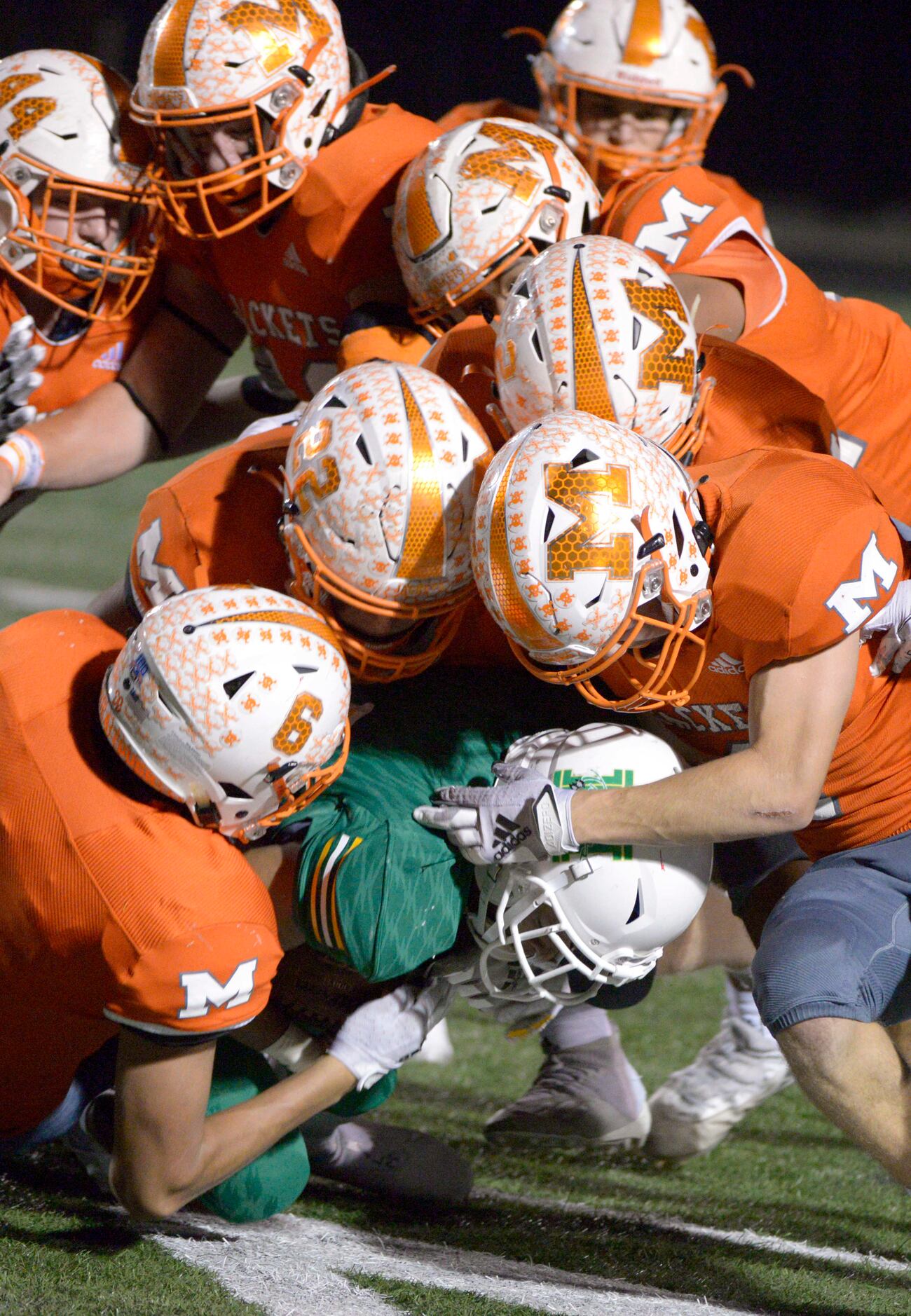 Mineola defenders team up to take down Madison’s Jayleen Record in the first quarter during...