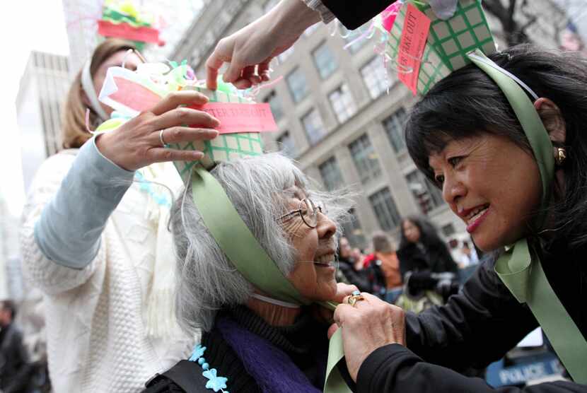 Terrie Furukawa, right, reties the hat of her aunt Yotsuko Sakamoto as they take part in the...