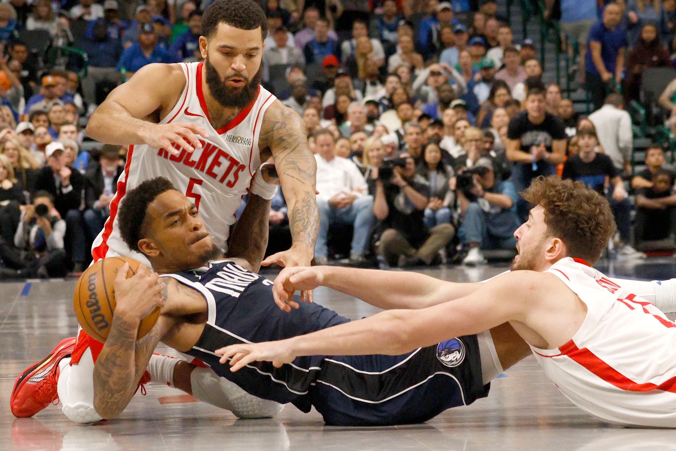 Dallas Mavericks forward P.J. Washington (25), center, keeps the ball away from Houston...