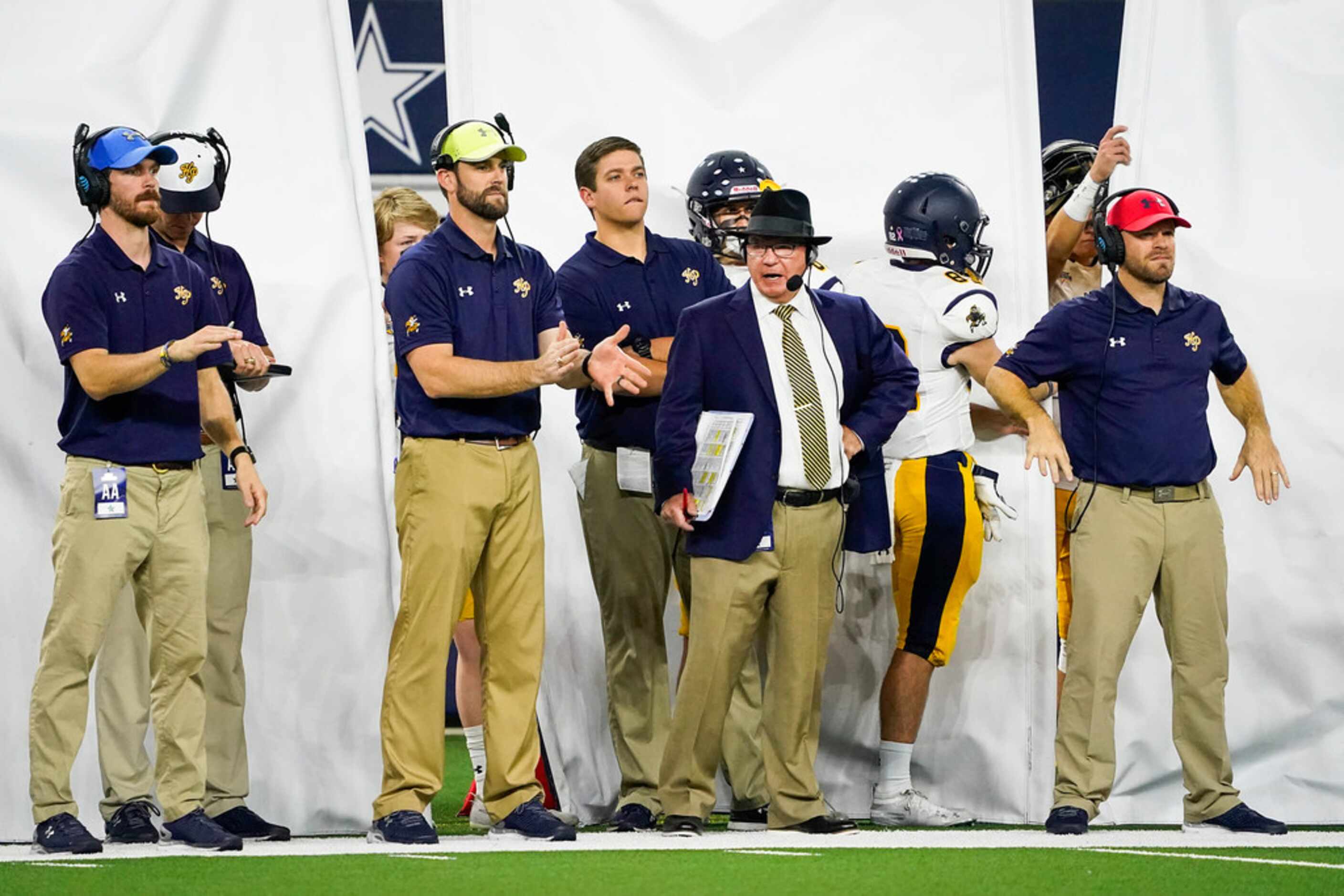 Highland Park head coach Randy Allen watches from the sidelines as his assistants signal in...