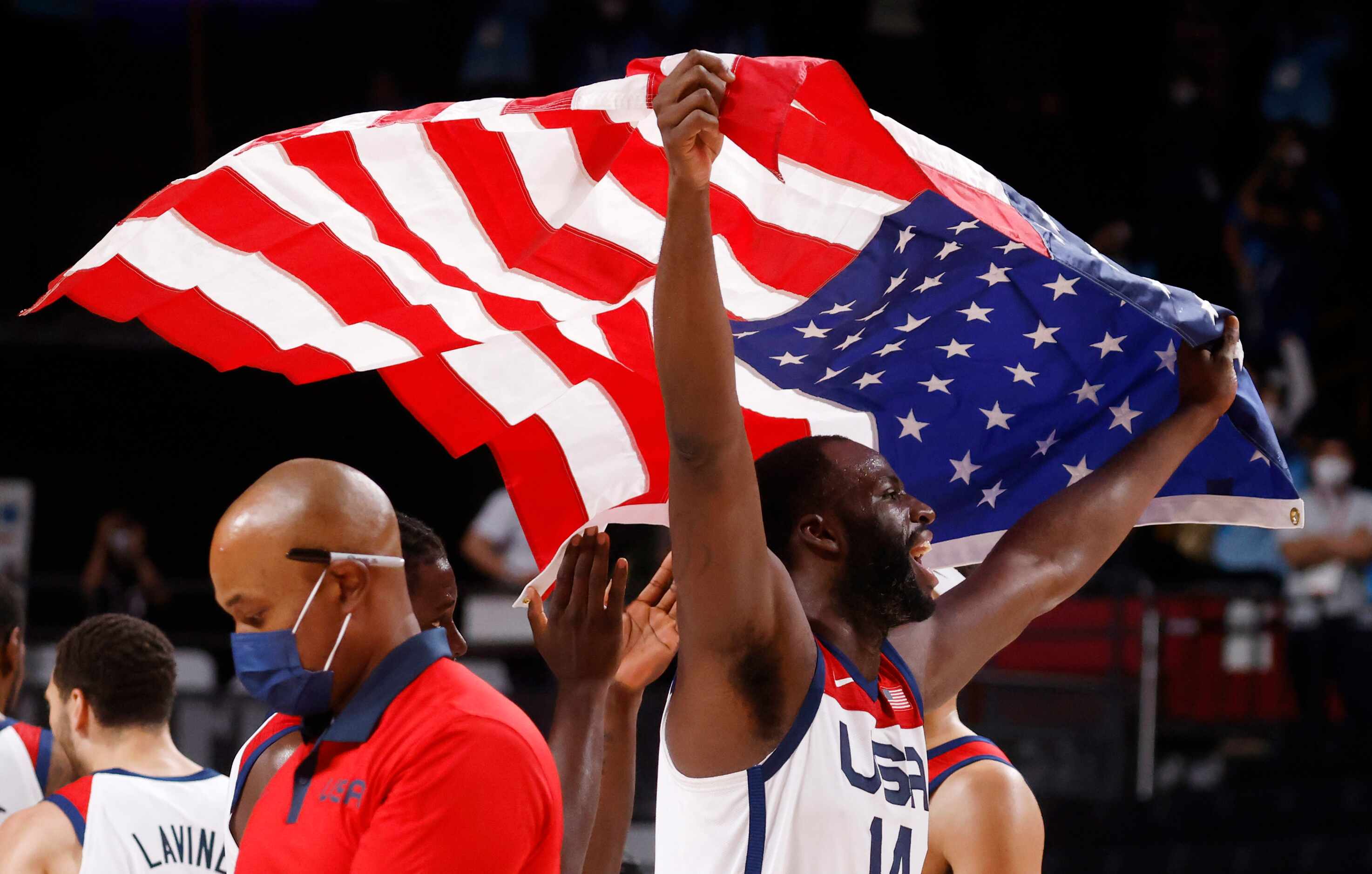 USA’s Draymond Green (14) celebrates holding up a flag after defeating France in the gold...