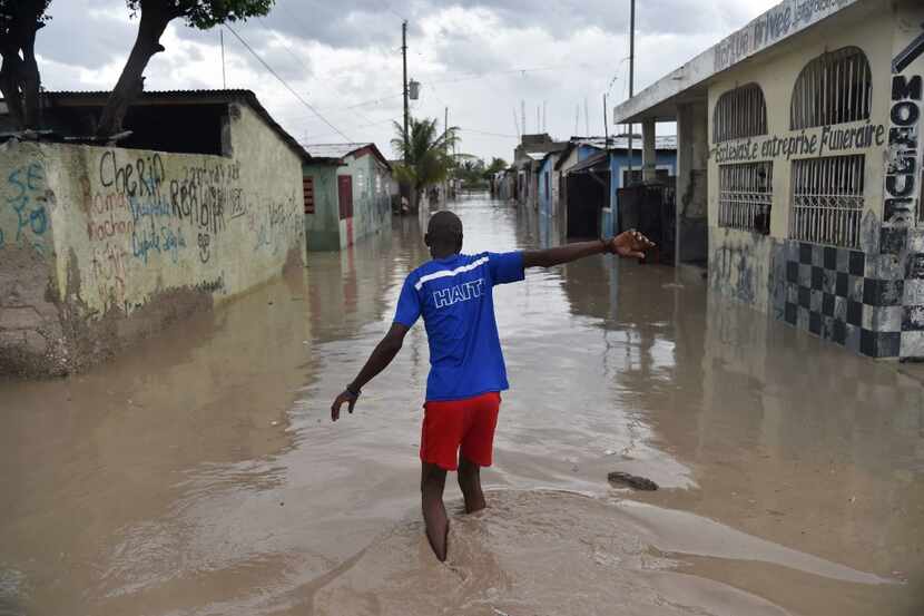 A man walked down a flooded street Tuesday in the Haitian Capital of Port-au-Prince.