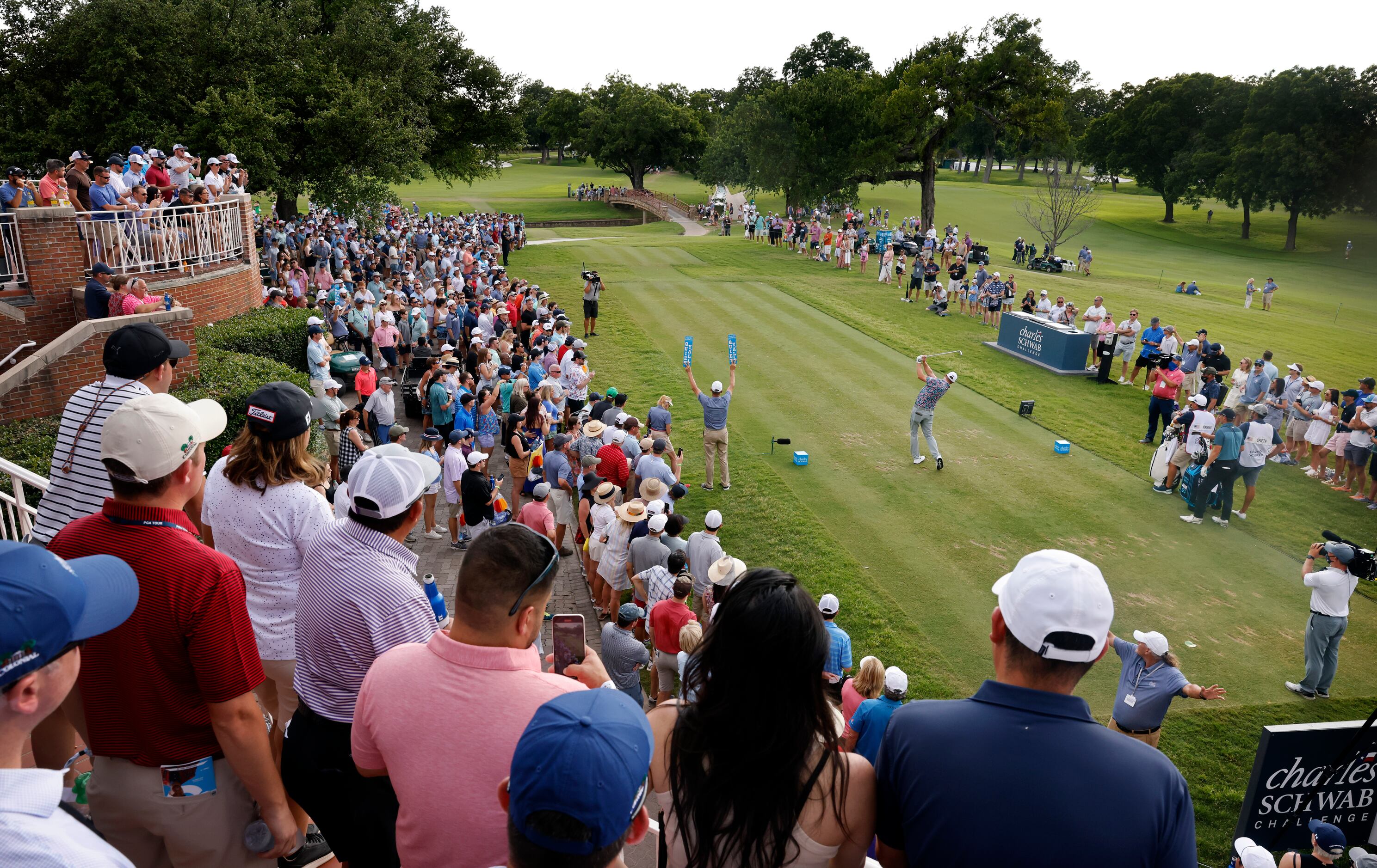 With a gallery of onlookers, professional golfer Jason Kokrak tees off on No. 17 during his...