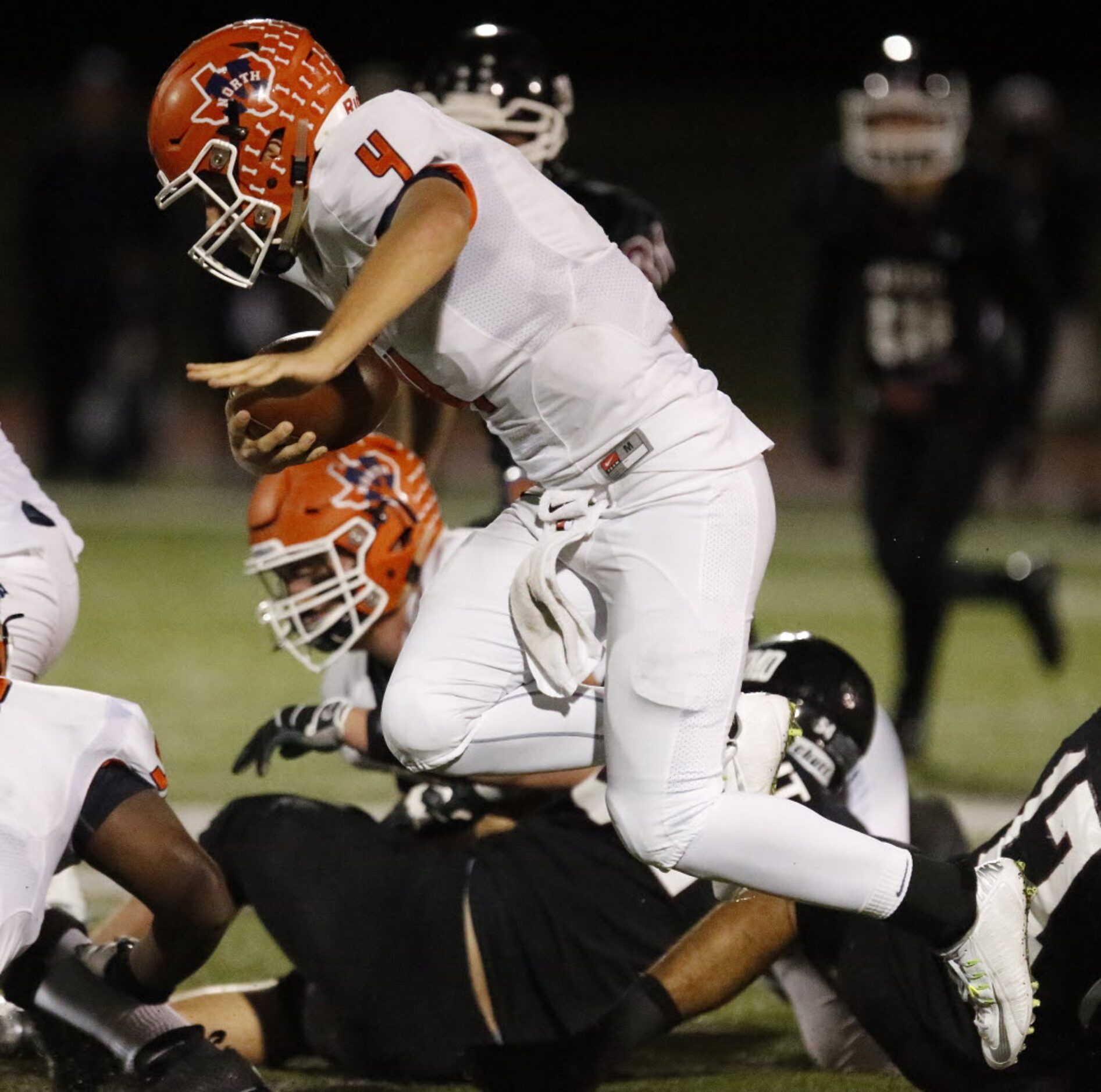 McKinney North High School quarterback Christian Files (4) keeps the football in the first...