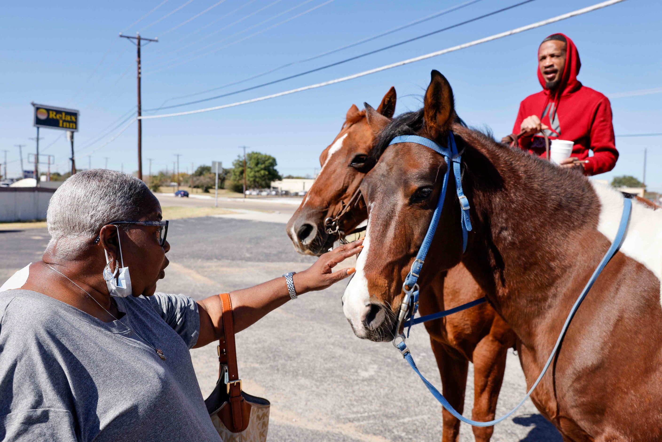 Cynthia Nickles, 62, of Forest Hill, pets Deuce as Markel Walker watches outside of Nellie...