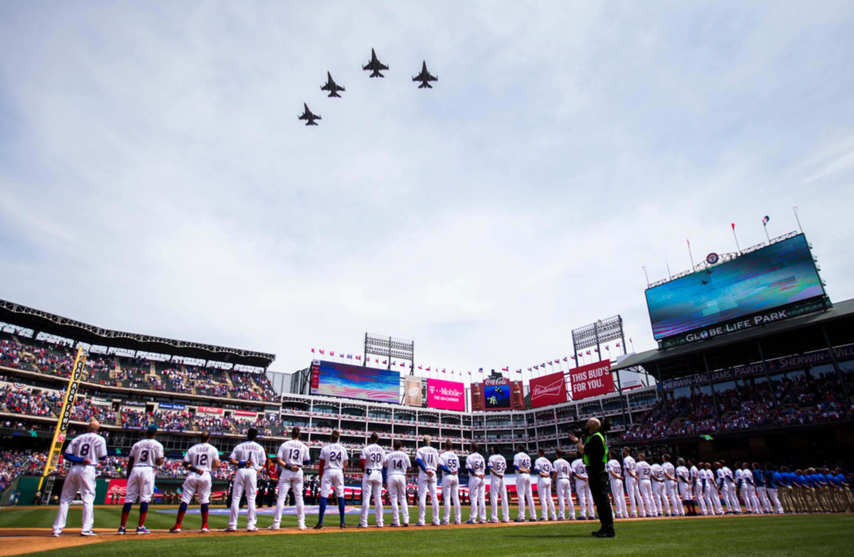 F-16 jet fighters fly over the Texas Rangers lineup before an opening day MLB game between...