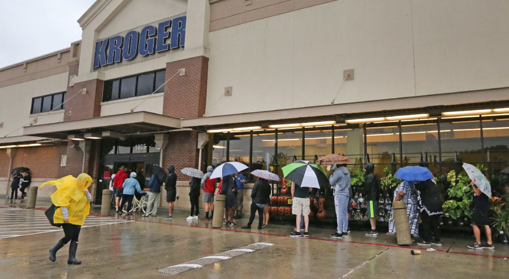 Shoppers wait in line in the rain to get into the Kroger store at North Shepherd and 11th...