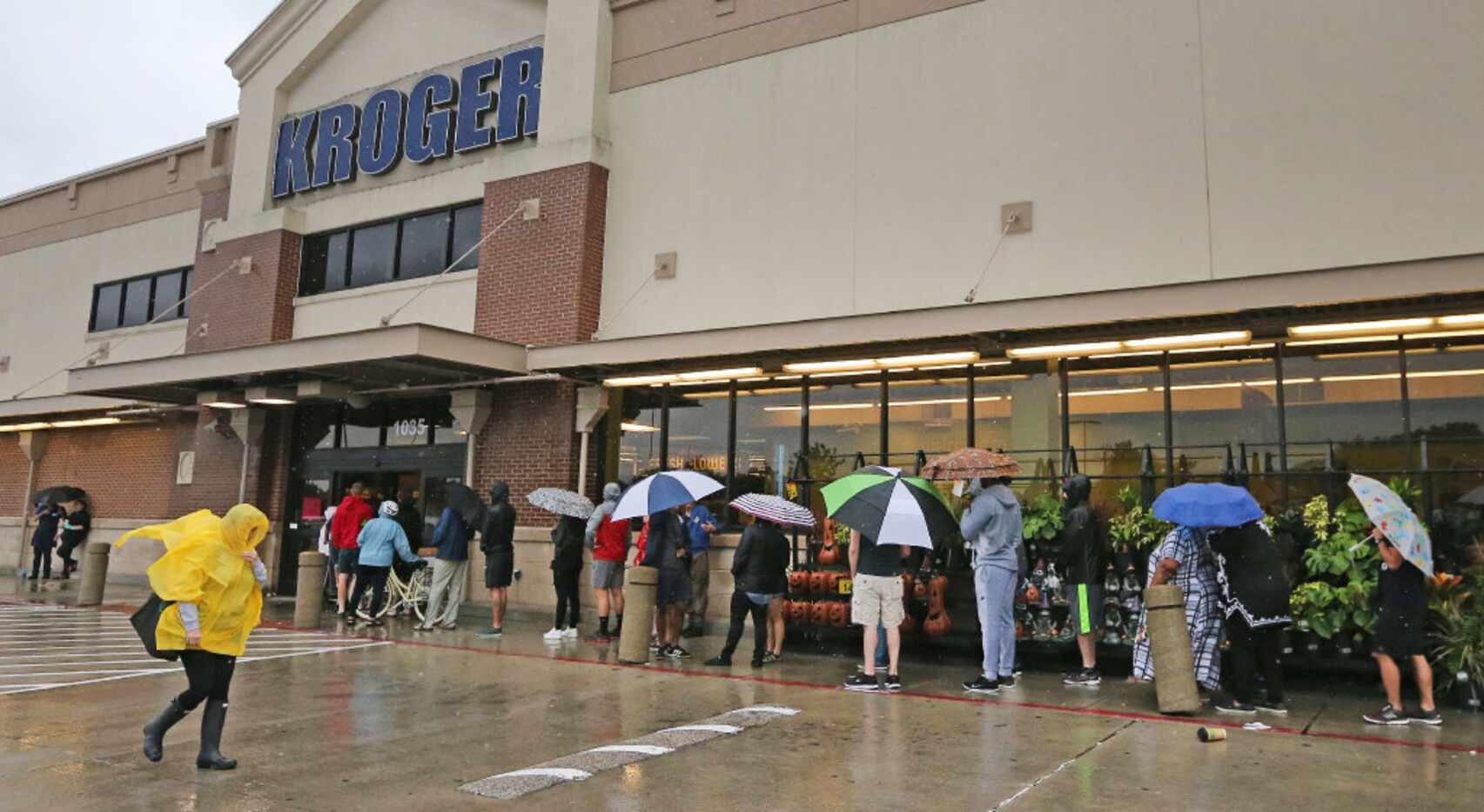 Shoppers wait in line in the rain to get into the Kroger store at North Shepherd and 11th...