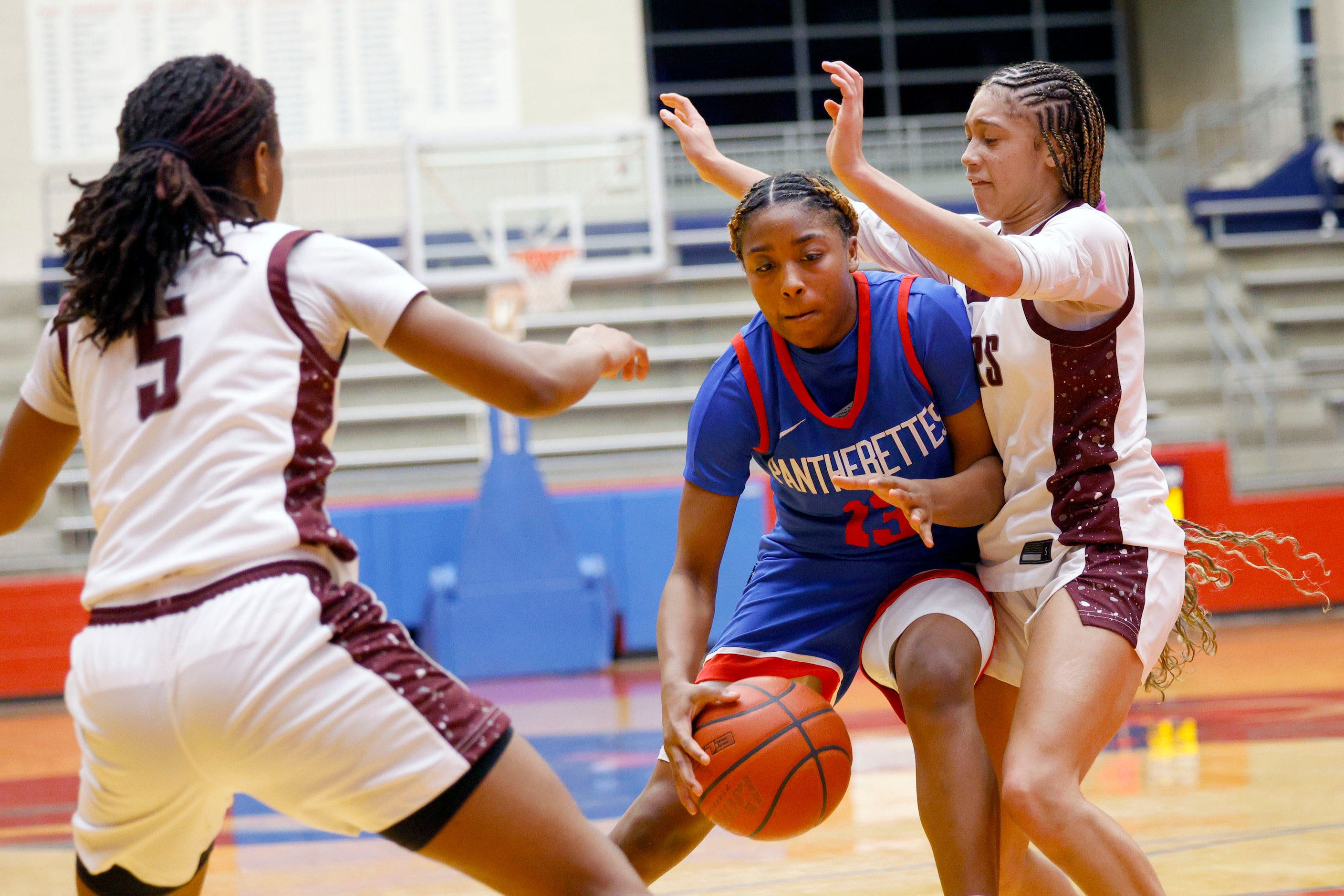 Duncanville's Samari Holmen (13) keeps the ball away from Pearland's Tycee Thibeaux (5) and...