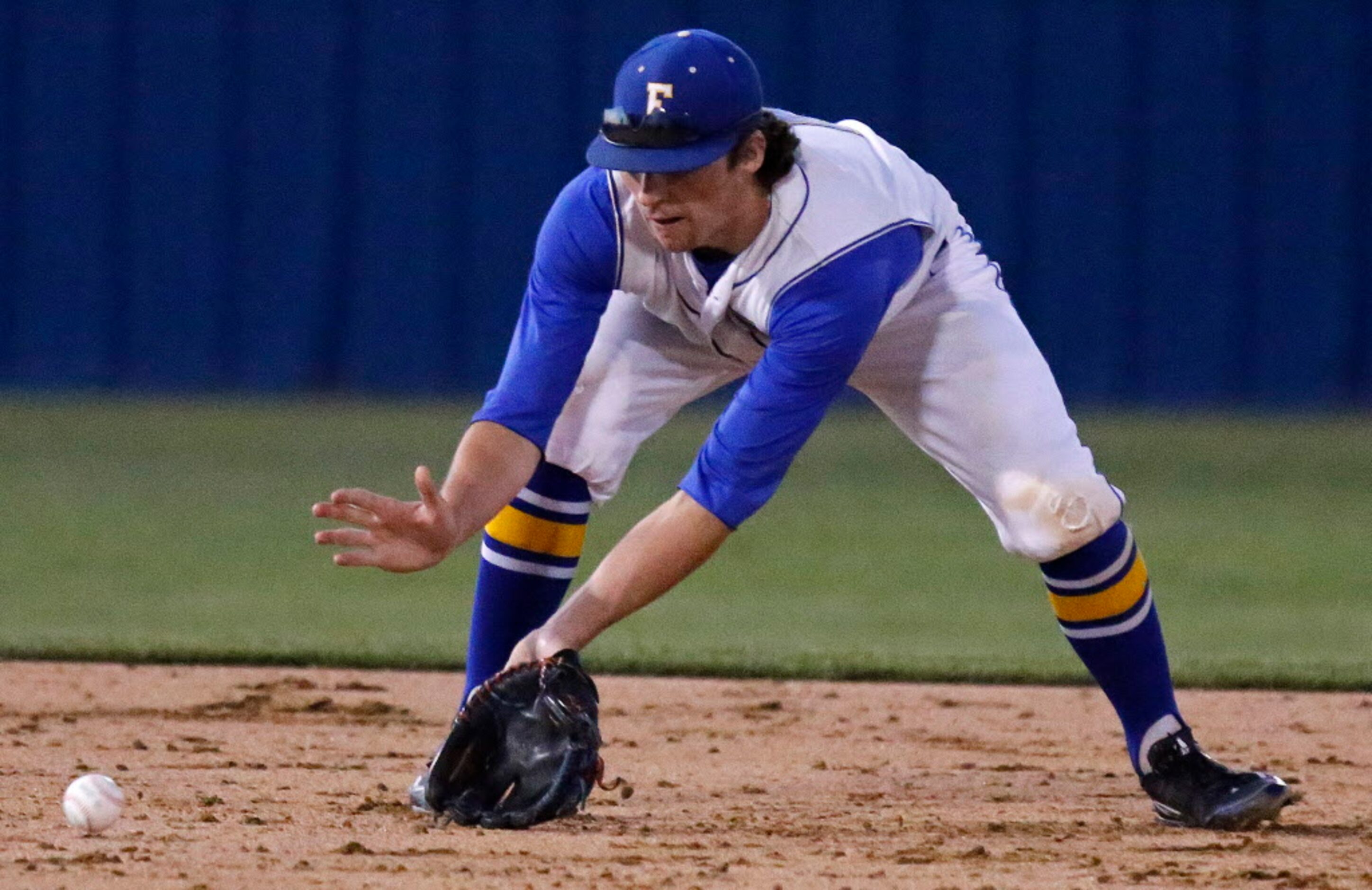 Frisco High School short stop Ryan Vilade (4) fields a ground ball during the second inning...