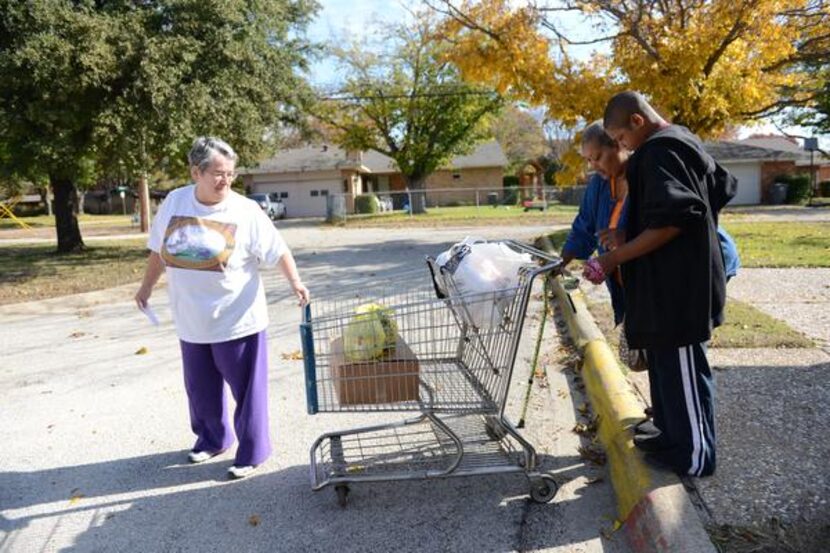 
Volunteer Mary MacDonald (left) helps Linda Wooten and her grandson LaDarrian Wooten with...