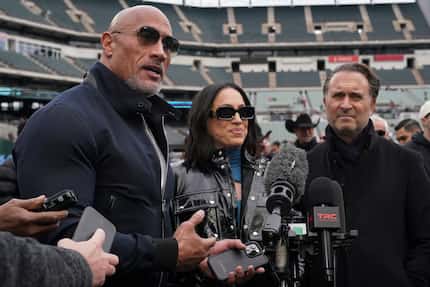 Dwayne “The Rock” Johnson stands next to his wife Dany Garcia and Gerry Cardinale while...