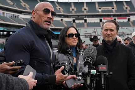 Dwayne “The Rock” Johnson stands next to his wife Dany Garcia and Gerry Cardinale while...