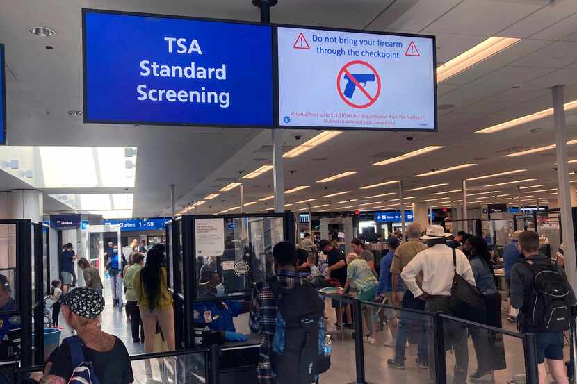 FILE - A sign warns travelers not to bring guns through the Transportation Security...