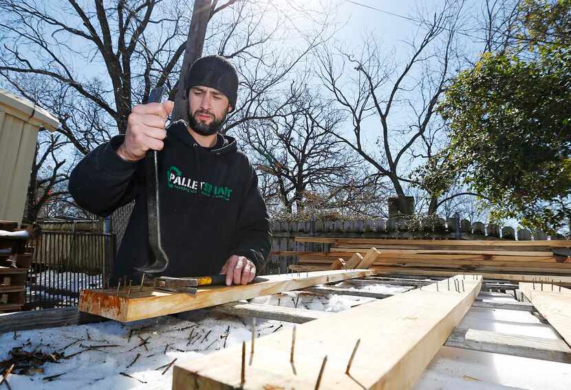 
Lucas White removes nails from pieces of wood from donated and recycled pallets.
