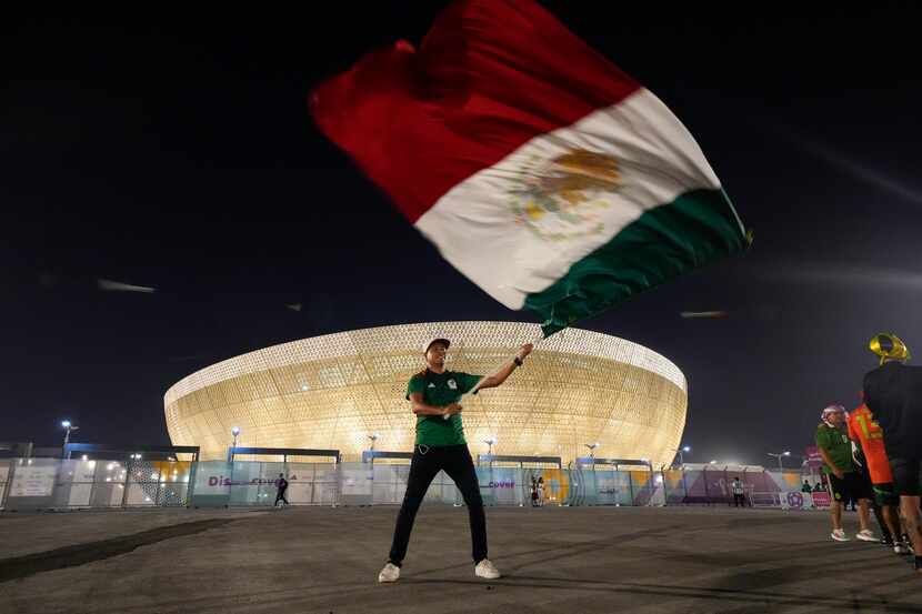 Luis Radilla, de Acapulco, México, ondea una bandera afuera del Estadio Lusail antes del...