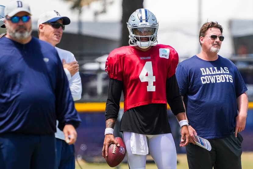 El mariscal de campo de los  Cowboys de DAllas,  Dak Prescott (4) observa con,del entrenador...