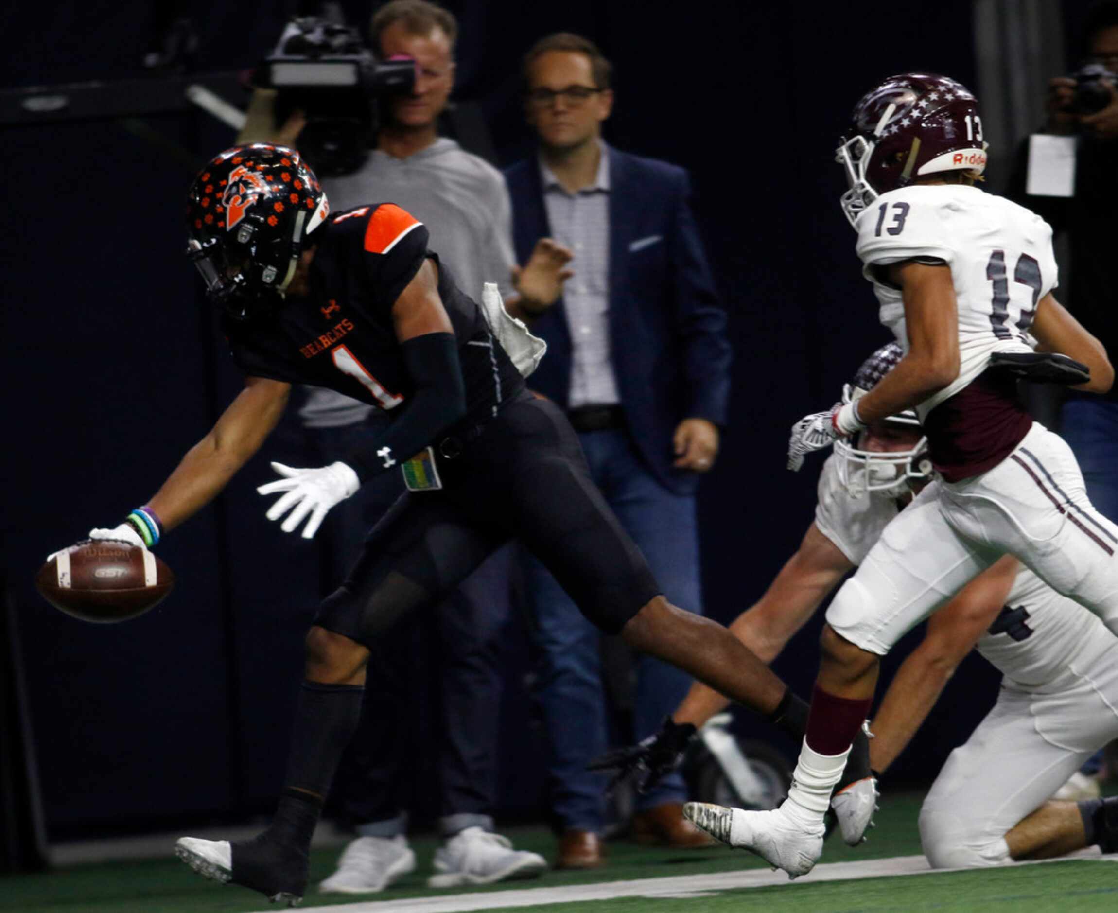 Aledo receiver JoJo Earle (1) stretches the ball out toward the goal line as he is chased by...