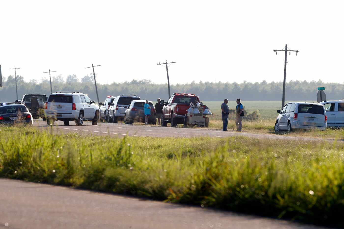 Emergency personnel stood along U.S. Highway 82 after a military transport plane crashed...